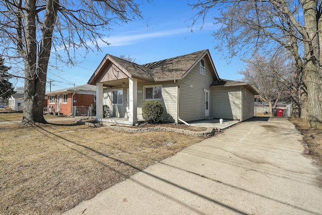 view of front facade with covered porch, driveway, and roof with shingles