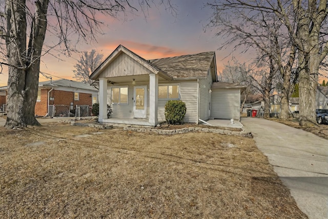 bungalow-style house featuring ceiling fan, covered porch, and concrete driveway