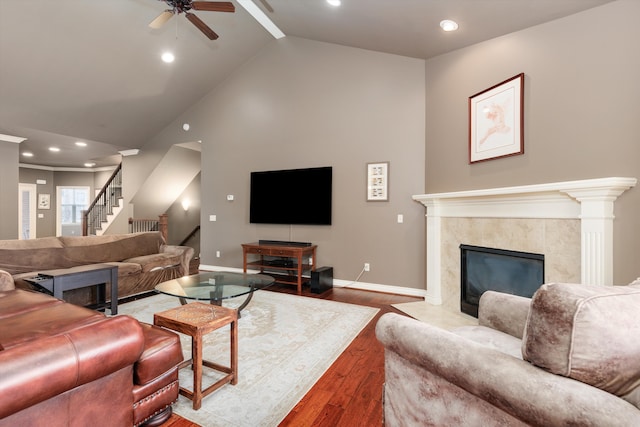 living area with baseboards, stairway, wood finished floors, and a high end fireplace