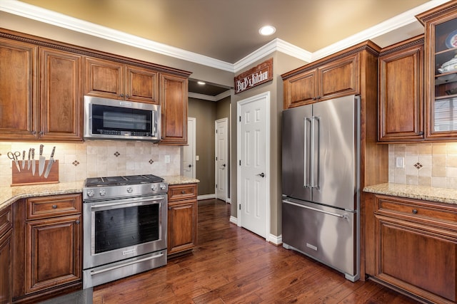 kitchen featuring stainless steel appliances, light stone countertops, and dark wood-style floors