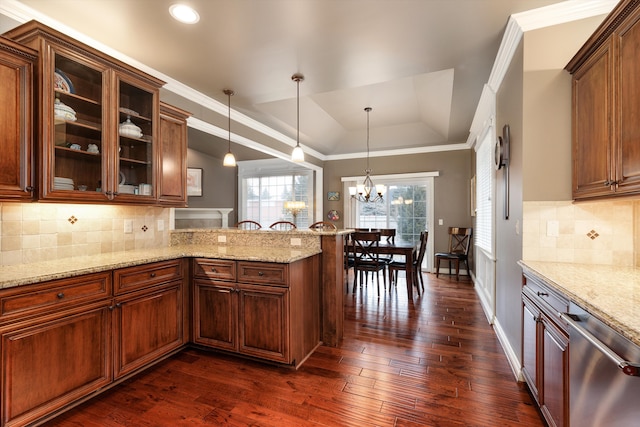 kitchen featuring light stone counters, dark wood finished floors, a raised ceiling, stainless steel dishwasher, and a peninsula