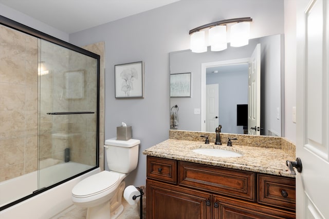 bathroom with toilet, combined bath / shower with glass door, and vanity