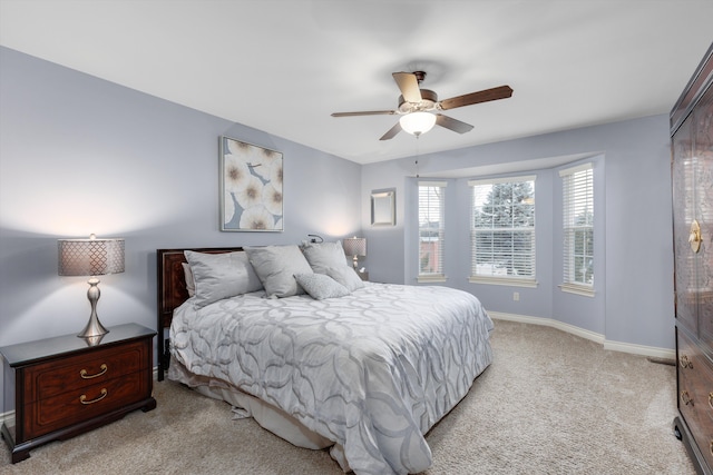 bedroom with ceiling fan, baseboards, and light colored carpet