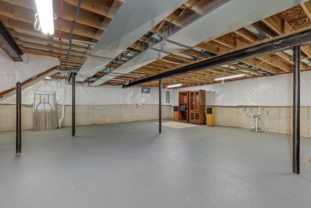 unfinished basement featuring brick wall