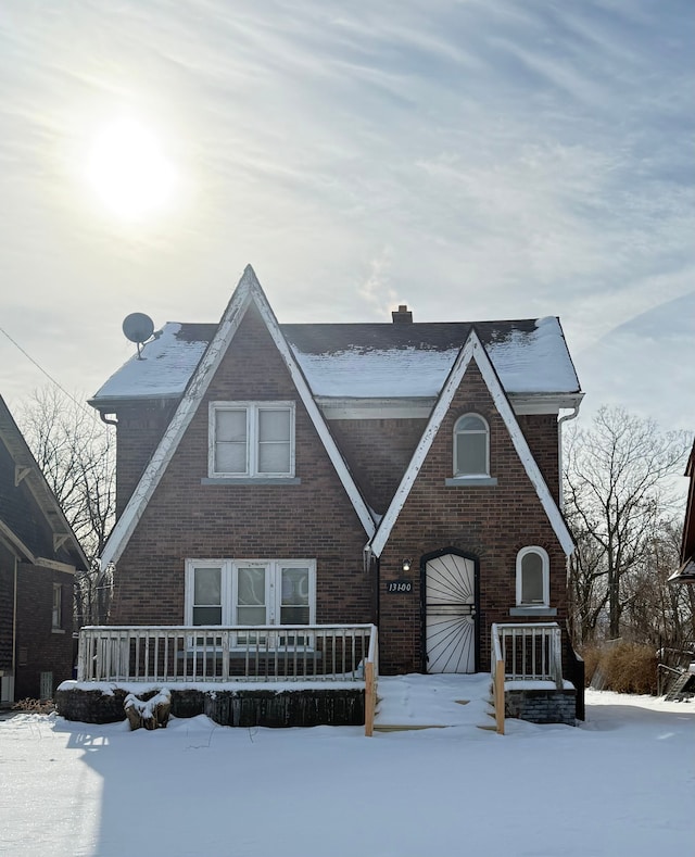 view of front facade with a chimney and brick siding