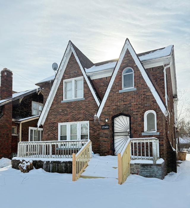 tudor house featuring brick siding