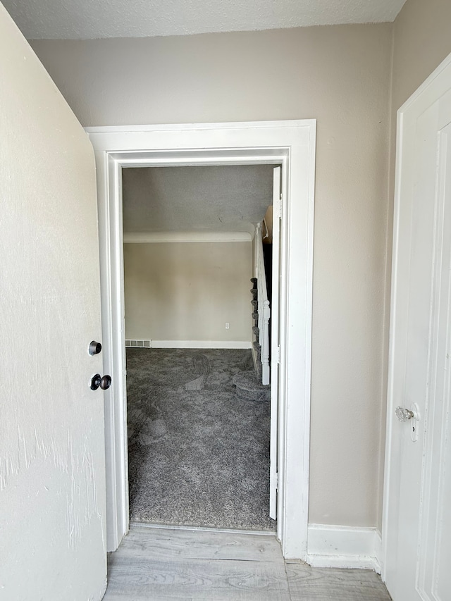 interior space with wood finished floors, carpet flooring, visible vents, and baseboards