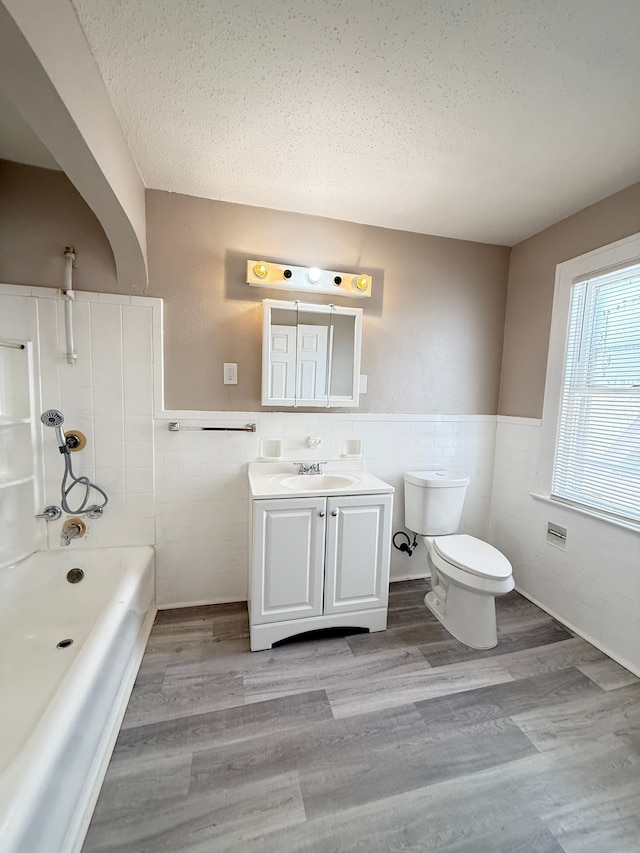 full bathroom with a wainscoted wall, vanity, toilet, and wood finished floors