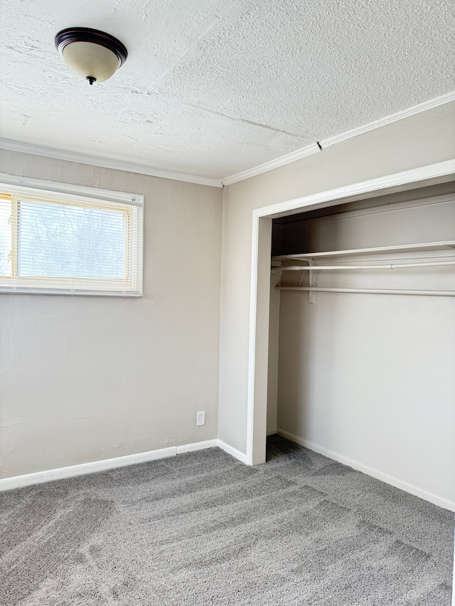 unfurnished bedroom featuring carpet, a textured ceiling, baseboards, and a closet