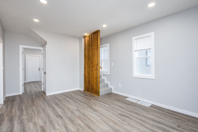 empty room featuring wood finished floors, visible vents, and recessed lighting