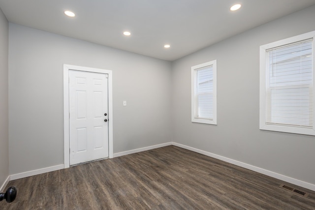 unfurnished room with dark wood-style flooring, recessed lighting, visible vents, and baseboards