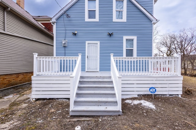 rear view of property featuring stairway and a deck