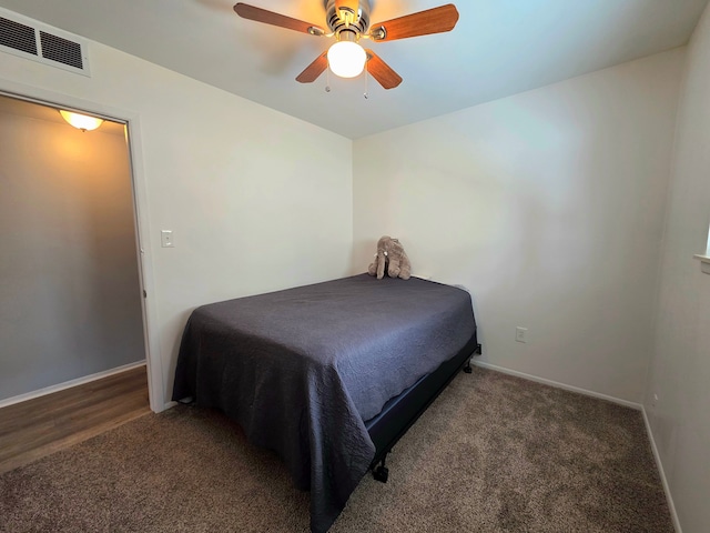 carpeted bedroom featuring a ceiling fan, visible vents, and baseboards