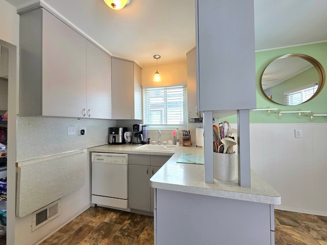 kitchen with visible vents, dishwasher, decorative light fixtures, light countertops, and a sink