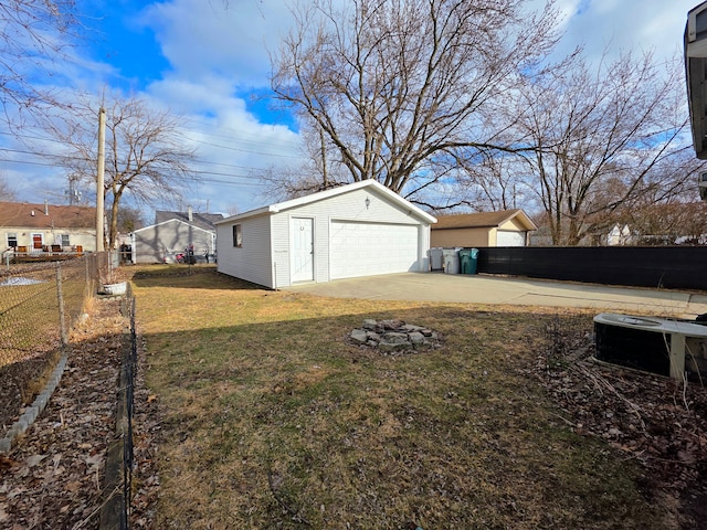 view of yard with a detached garage, fence, and an outdoor structure