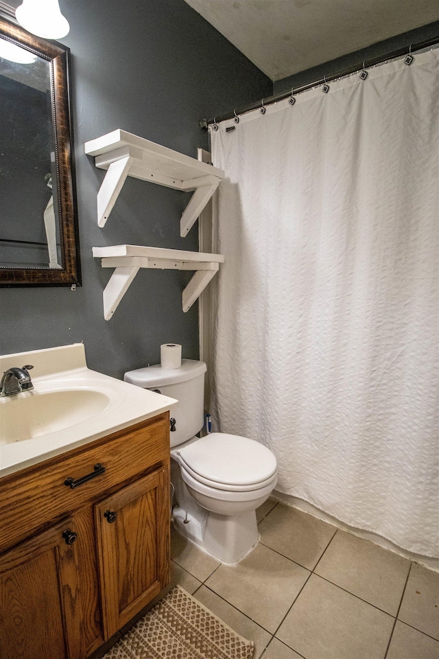 bathroom with toilet, tile patterned floors, vanity, and curtained shower