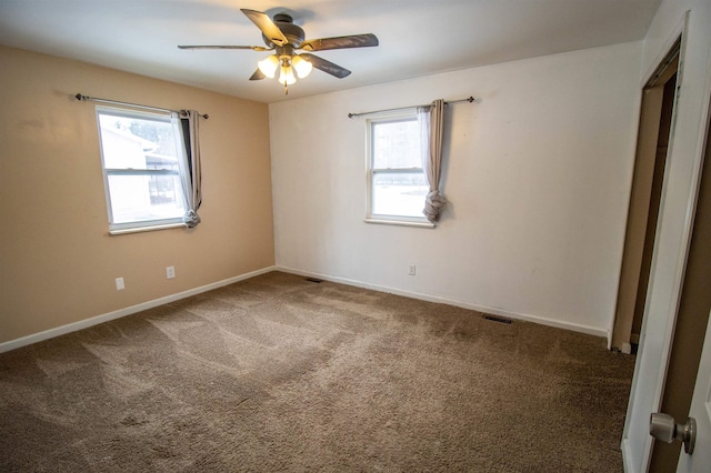 spare room featuring a ceiling fan, carpet, visible vents, and baseboards