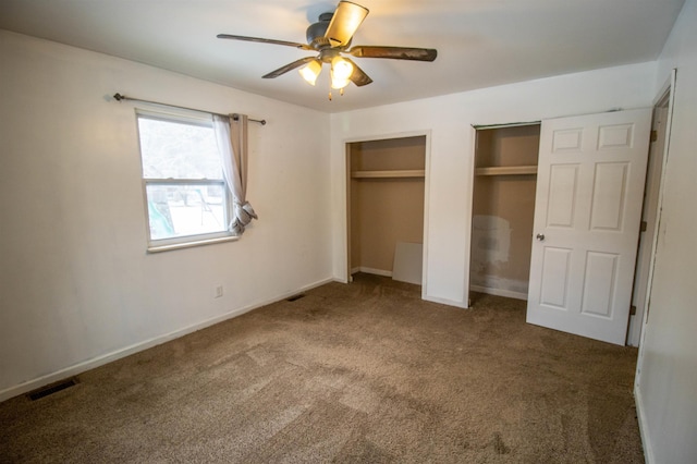 unfurnished bedroom with multiple closets, visible vents, carpet flooring, ceiling fan, and baseboards