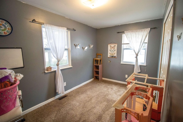 playroom featuring carpet, a healthy amount of sunlight, visible vents, and baseboards