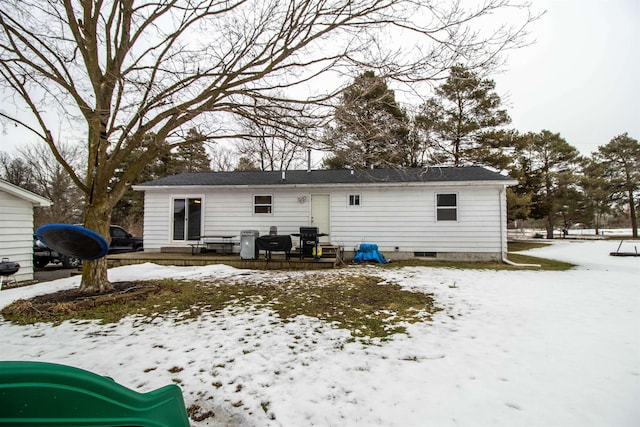 view of snow covered rear of property