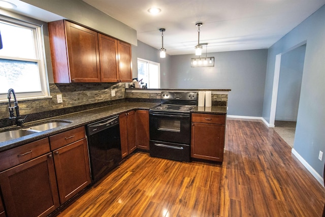 kitchen with black appliances, a sink, dark wood-style flooring, a peninsula, and hanging light fixtures