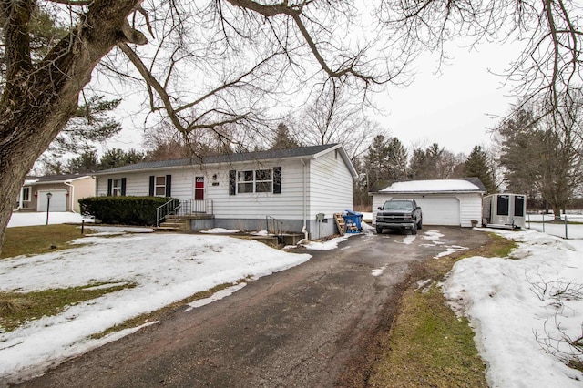 view of front facade featuring driveway, an outdoor structure, and a detached garage