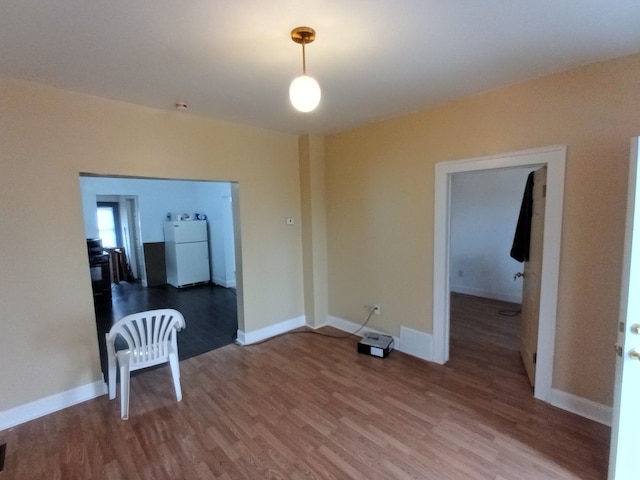 spare room featuring baseboards and wood finished floors