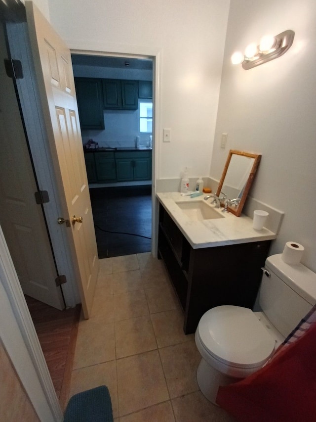 bathroom with tile patterned flooring, vanity, and toilet