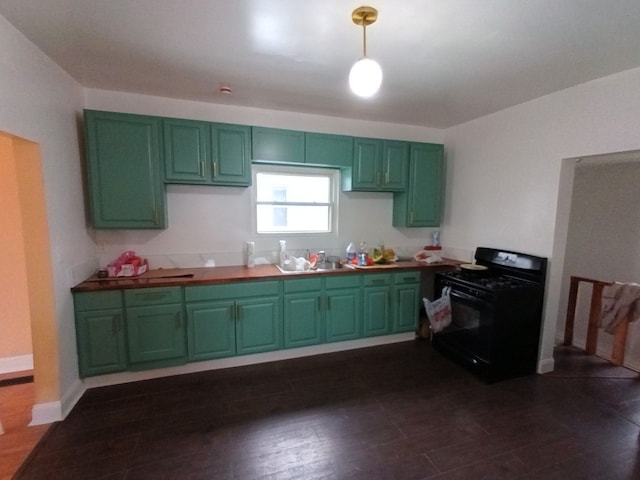 kitchen featuring green cabinets, dark wood-style flooring, baseboards, and black gas range oven