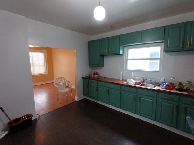 kitchen featuring dark wood-style flooring, green cabinetry, and plenty of natural light