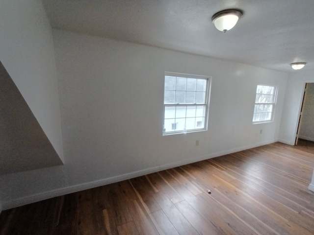 empty room with baseboards and wood finished floors