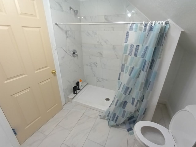 bathroom featuring marble finish floor, a stall shower, and toilet