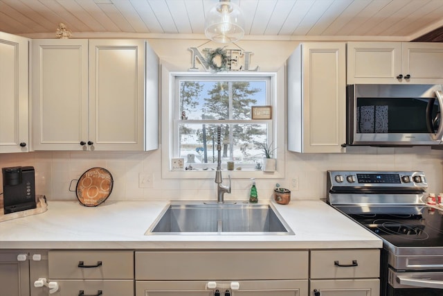 kitchen with backsplash, wood ceiling, stainless steel appliances, and a sink