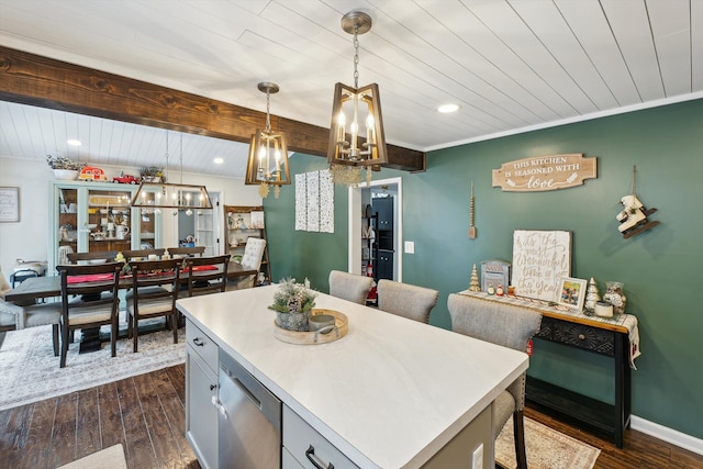 kitchen featuring dark wood-type flooring, a kitchen island, light countertops, beamed ceiling, and decorative light fixtures