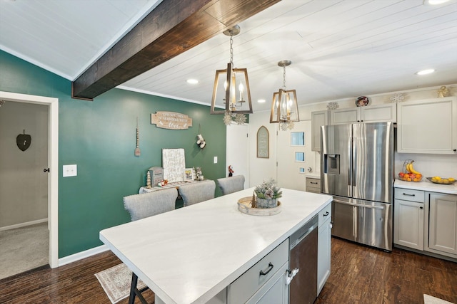 kitchen featuring dark wood finished floors, stainless steel appliances, light countertops, a kitchen island, and baseboards