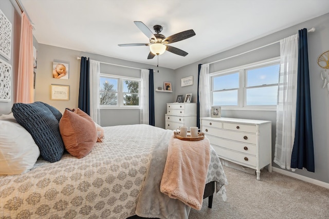 bedroom with light colored carpet, ceiling fan, and baseboards