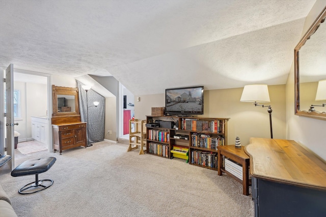 sitting room with carpet, baseboards, vaulted ceiling, and a textured ceiling