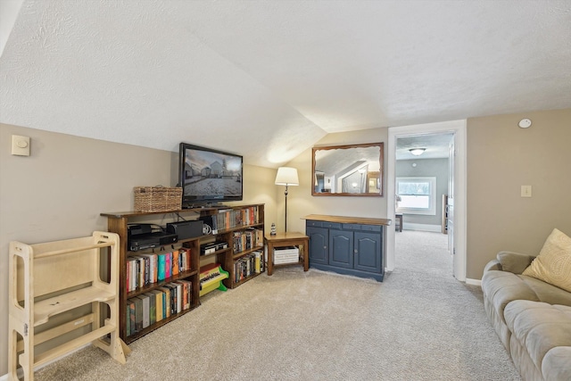 interior space with lofted ceiling, light carpet, baseboards, and a textured ceiling