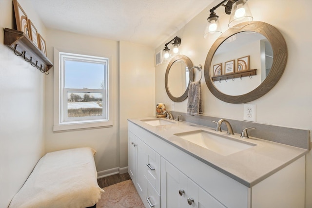 bathroom featuring double vanity, baseboards, visible vents, and a sink