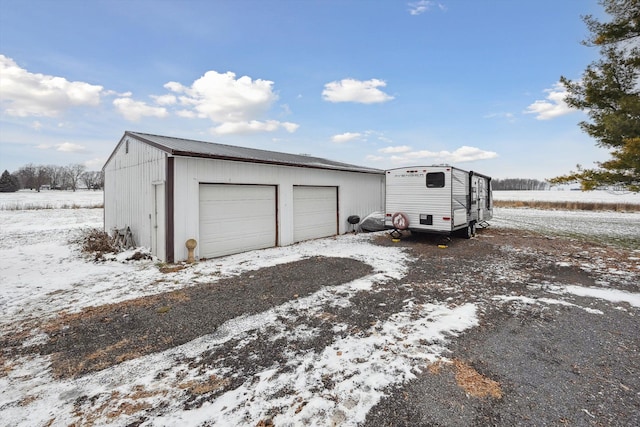 snow covered garage featuring a garage