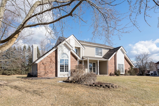 traditional home with a front yard, brick siding, and a chimney