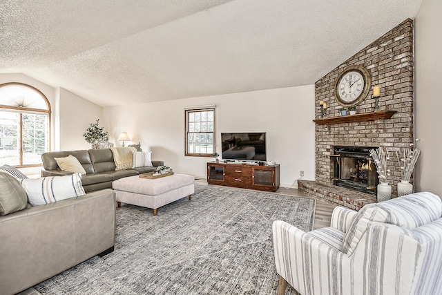 living room featuring vaulted ceiling, a textured ceiling, a fireplace, and wood finished floors