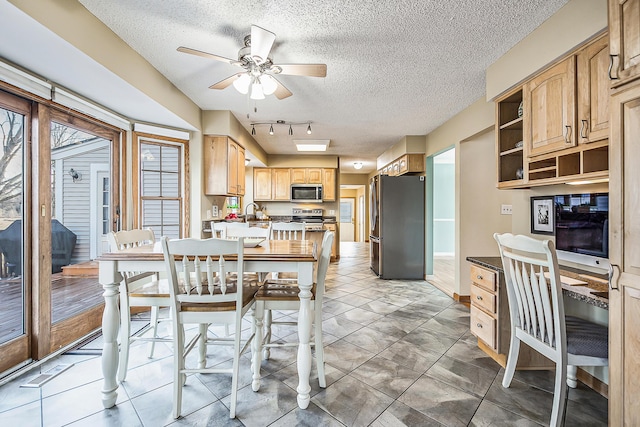 kitchen featuring ceiling fan, a textured ceiling, stainless steel appliances, a peninsula, and open shelves