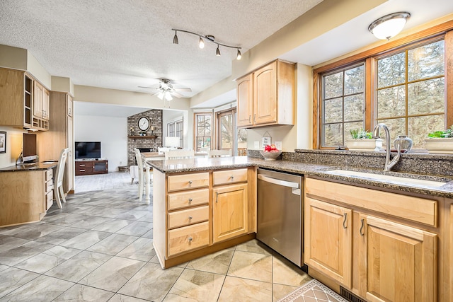 kitchen with dishwasher, ceiling fan, open floor plan, light brown cabinetry, and a sink