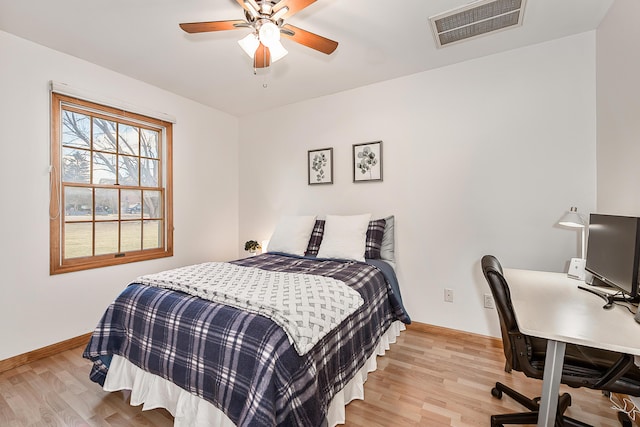 bedroom with ceiling fan, light wood-style flooring, visible vents, and baseboards