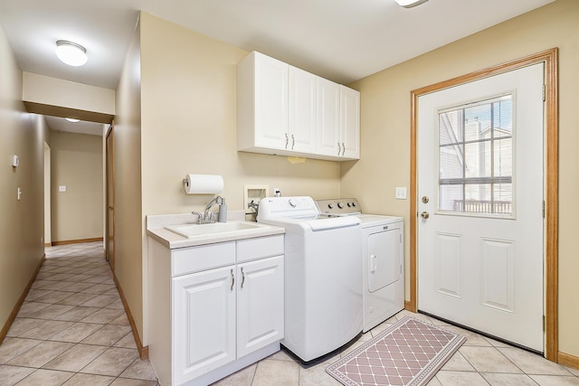 laundry room with light tile patterned floors, cabinet space, baseboards, separate washer and dryer, and a sink