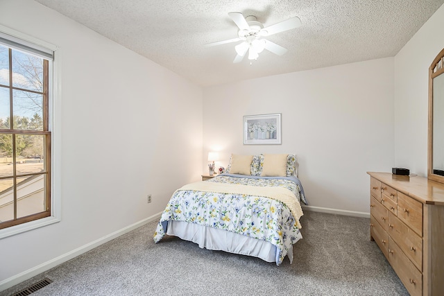 carpeted bedroom featuring visible vents, a textured ceiling, and baseboards