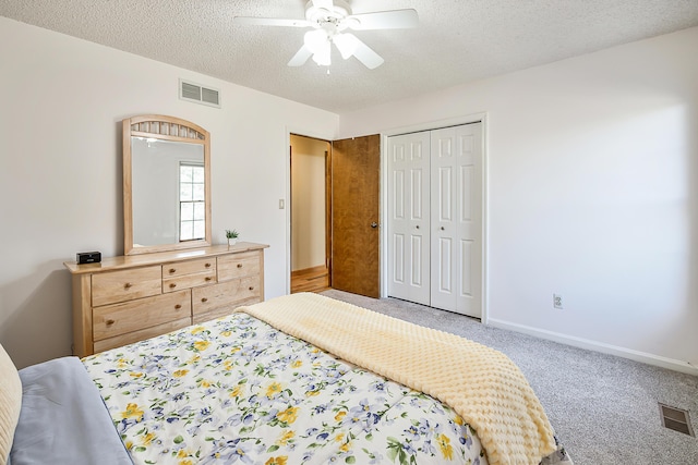 bedroom featuring a textured ceiling, carpet flooring, visible vents, and baseboards