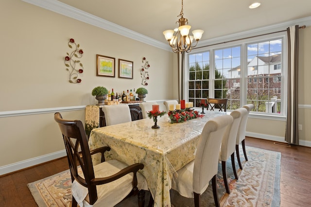 dining area featuring a chandelier, ornamental molding, dark wood finished floors, and baseboards