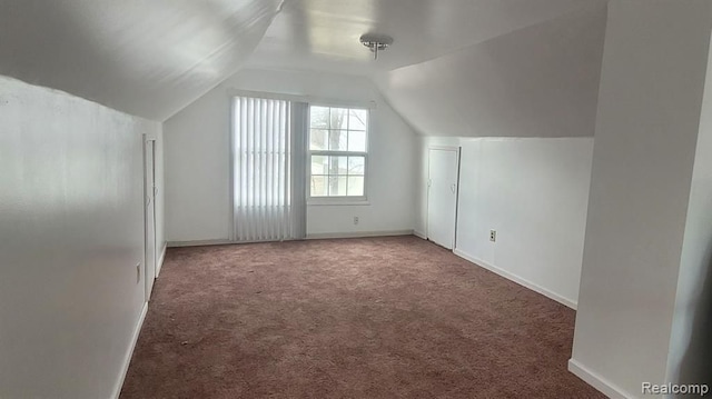 additional living space with lofted ceiling, carpet flooring, and baseboards